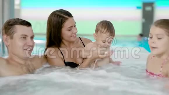 年轻的父母和孩子花时间在游泳池里视频的预览图