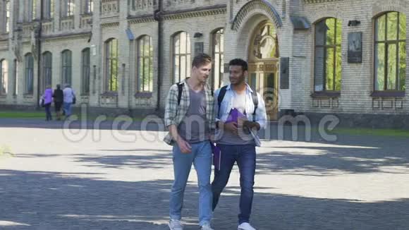 男性最好的朋友走在学院附近互相交谈学生视频的预览图