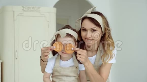 妈妈用饼干遮住小女儿眼睛一个幸福的家庭视频的预览图