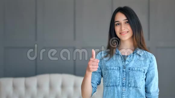 快乐微笑的年轻女子在室内展示成功和手势视频的预览图