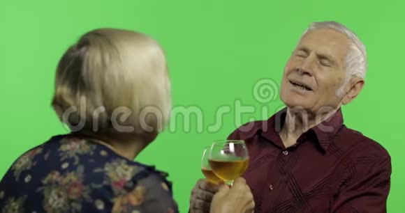 老年男子与老年妇女在chroma键上的伴侣喝酒视频的预览图