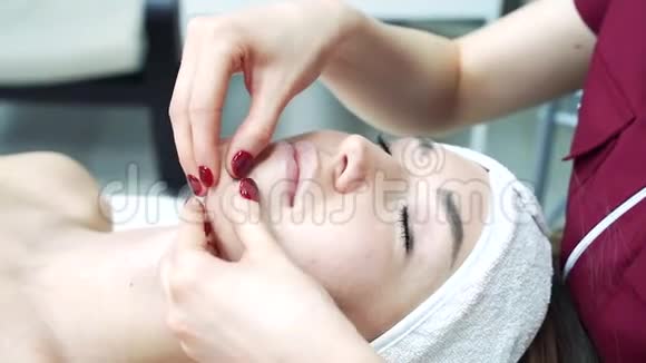 美容诊所年轻女性做专业的面部手术美容师在女性脸上做按摩视频的预览图
