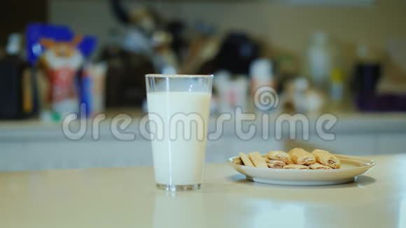清淡的早餐不可辨认的女人来到餐桌前喝着杯子里的牛奶视频的预览图