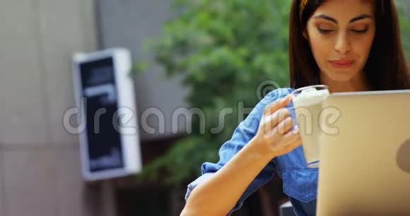 在4k室外咖啡厅使用笔记本电脑的女士视频的预览图