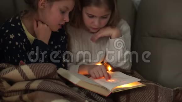 女孩们开了个睡衣派对姐妹们读一本书讨论他们的内容圣诞灯视频的预览图