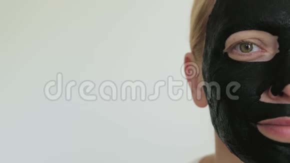 半张脸上戴黑色化妆面具的女人特写视频的预览图