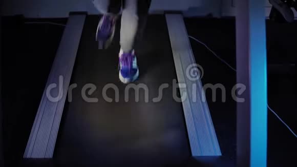 在健身房的跑步机上穿蓝色运动鞋的女性脚视频的预览图