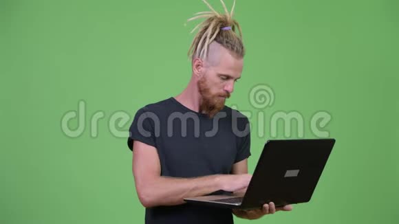 一个长着大胡子的男人在使用笔记本电脑时会有可怕的思维视频的预览图