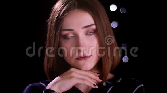 在镜头前用bokeh背景摆姿势的年轻漂亮短发女性特写镜头视频的预览图