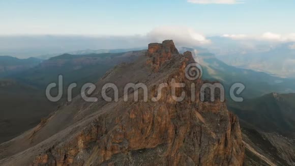 傍晚日落时专业鸟瞰一座岩石山悬崖峭壁极限攀登概念视频的预览图