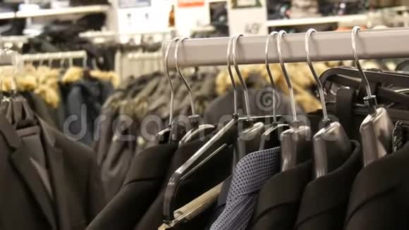 中国男装商店的衣架上挂着许多不同款式的黑色夹克和衬衫视频的预览图