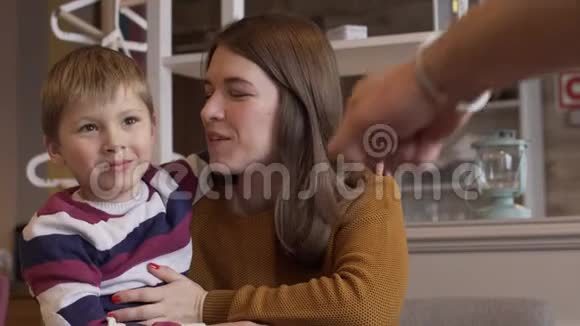 年轻的妈妈拥抱她的小儿子并与他交谈视频的预览图