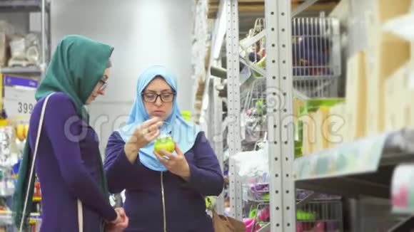 美丽的母亲和女儿穆斯林妇女购物讨论商品视频的预览图