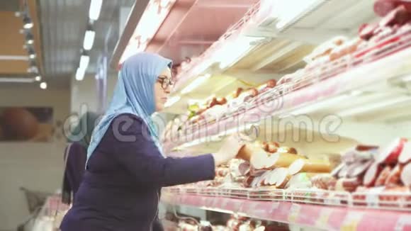 有魅力的女人戴着头巾购物40年肉类部门视频的预览图