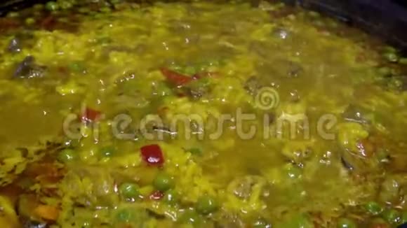 厨师用胡椒和鸡肝在煎锅里煮黄米饭视频的预览图