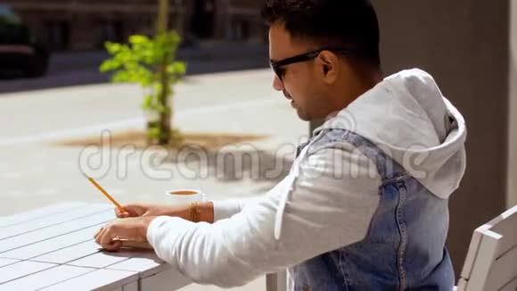 有笔记本和咖啡的人在街头咖啡馆视频的预览图