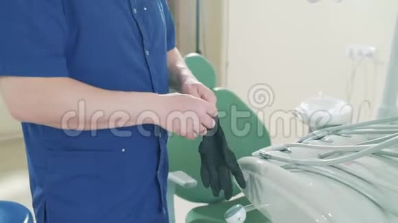 一个穿着医用长袍手臂上戴着医用手套的男子慢镜头的裁剪框架的特写视频的预览图
