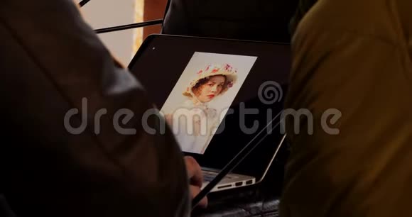 摄影师在笔记本电脑拍照后翻拍模特照片视频的预览图