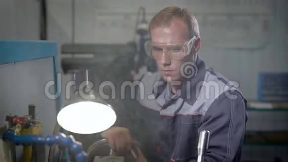 一个工人在工厂的机器上在车床上工作的人工装制造视频的预览图