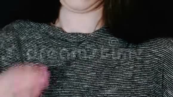 特写女人她的手把拉瓦利尔麦克风连接到黑色背景上的衬衫上视频的预览图