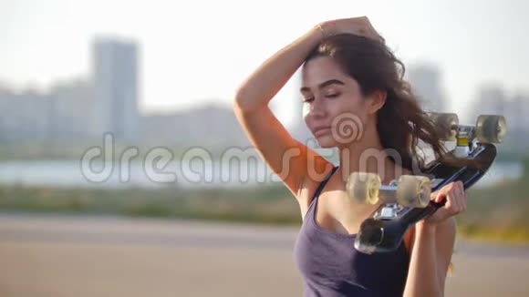 一个漂亮的女孩一只手拿着溜冰鞋另一只手拉着她的头发看着相机视频的预览图
