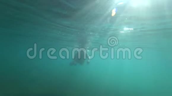 潜水年轻人在水下游泳眼睛睁着明亮的阳光穿透视频的预览图