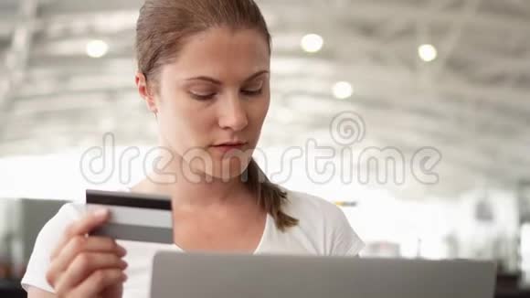 在机场等待航班起飞时女士用笔记本电脑上网购物视频的预览图