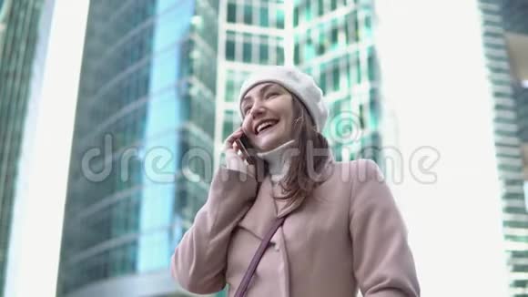 年轻女子在一个大城市的高楼间打电话视频的预览图