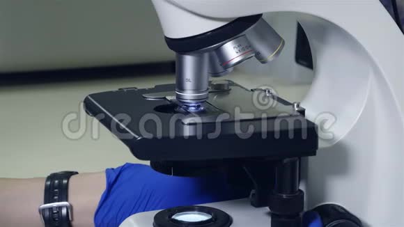 显微镜的特写研究材料的平台从显微镜的镜头下移动视频的预览图