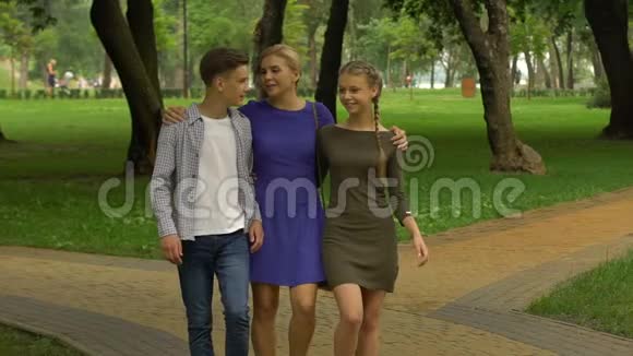 十几岁的男孩和女孩在校园里和母亲散步计划开始上大学视频的预览图