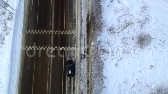 黑车在雪地里行驶在高速公路上从无人驾驶飞机上俯瞰视频的预览图