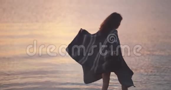 在海滩上享受美丽日落的女人视频的预览图
