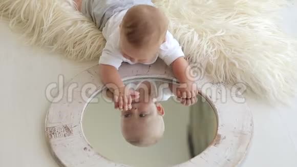 一个5个月大的婴儿躺在床上在家里玩镜子视频的预览图