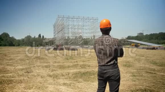满怀信心的建筑师在未来工厂的建设中双手交叉站在草田上视频的预览图