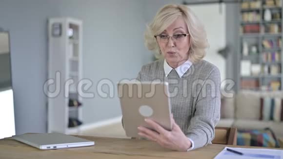 老女人在桌上做视频聊天视频的预览图