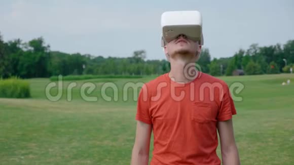 一个男人在公园里用VR耳机环顾四周视频的预览图