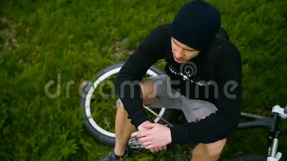 那家伙骑着自行车在草地上休息视频的预览图