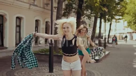 漂亮的时髦女人在街上奔跑穿着短裤的女孩微笑视频的预览图