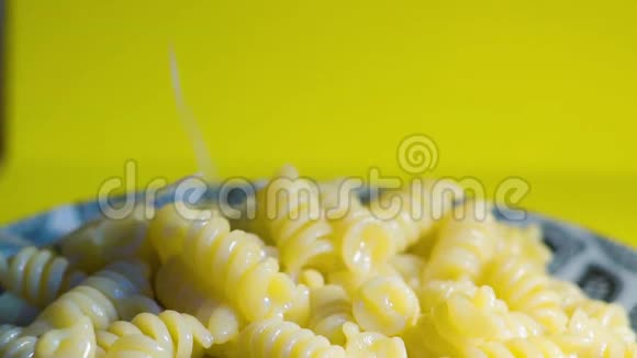 在盘子里的意大利面中加入一个奶酪奶酪落在意大利面上通心粉特写慢动作视频的预览图