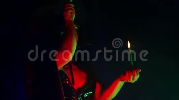 一个年轻女巫的脸手里拿着蜡烛念着咒语用魔杖处理魔法视频的预览图
