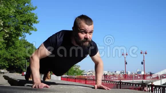 这个留胡子的人在早上的户外训练中做俯卧撑城市健身训练视频的预览图