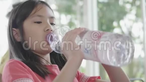 儿童饮水瓶小女孩手里拿着水瓶在餐馆里视频的预览图
