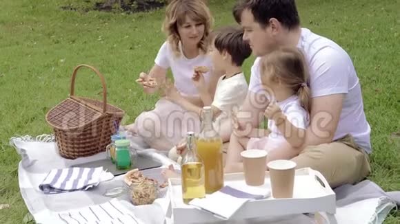 快乐的家庭吃披萨在野餐中玩得开心视频的预览图