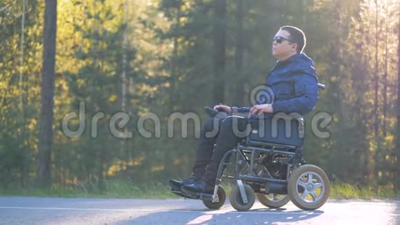 坐轮椅的残疾人正在享受自己和周围的自然环境视频的预览图