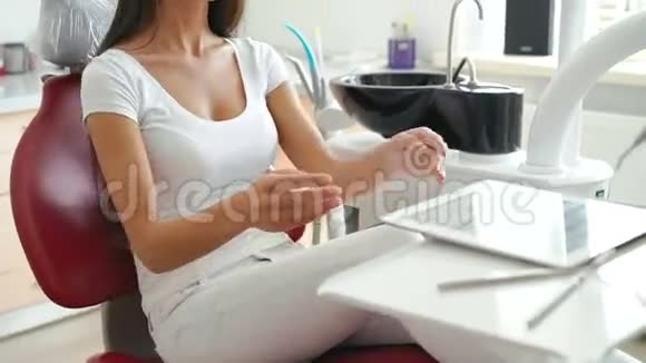 坐在牙医椅上拿着药片的女人微笑着视频的预览图