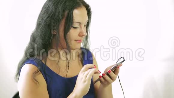 一位年轻女子在手机上播放音乐视频的预览图