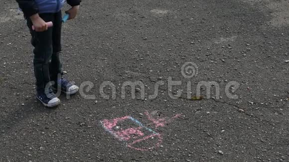 男孩用粉笔在沥青上画画视频的预览图