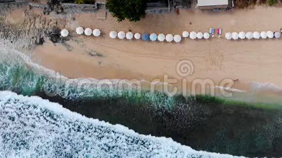 鸟瞰海滩巴厘岛有太阳伞和绿松石海视频的预览图