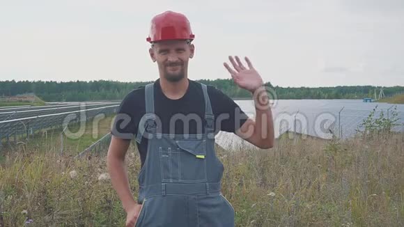 太阳能电站的工人微笑着挥动他的手视频的预览图