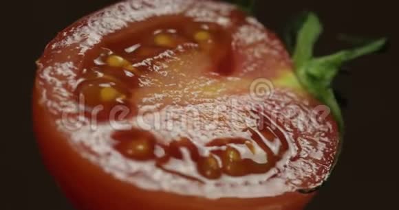 在黑暗的背景下旋转新鲜的成熟番茄的一半视频的预览图
